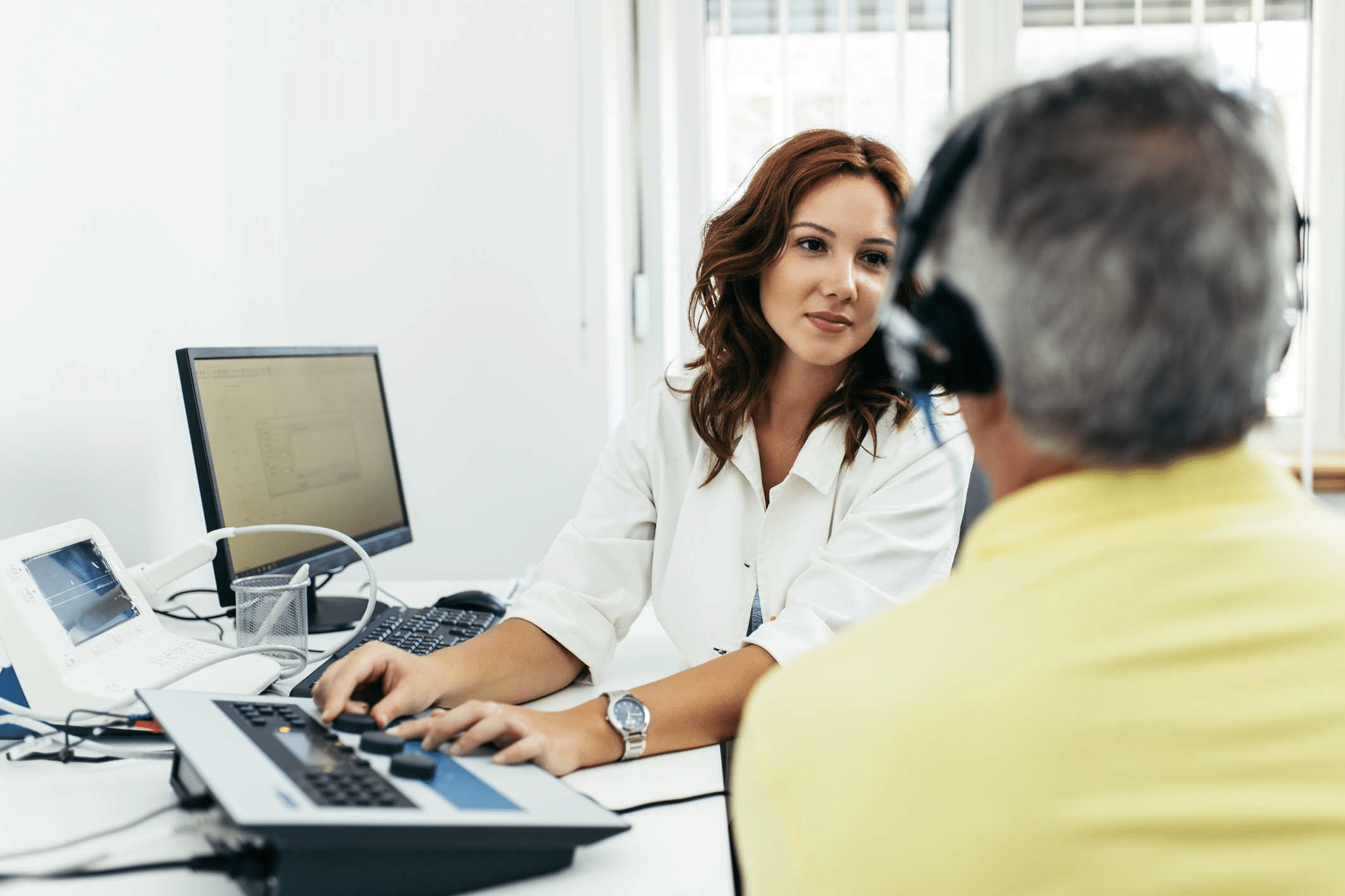 A Taylor Hearing Centers audiologist explains the types of hearing loss to a patient during an exam.