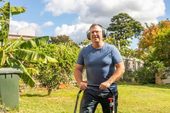 A man mowing his lawn in Tennessee wears hearing protection to help prevent hearing loss.